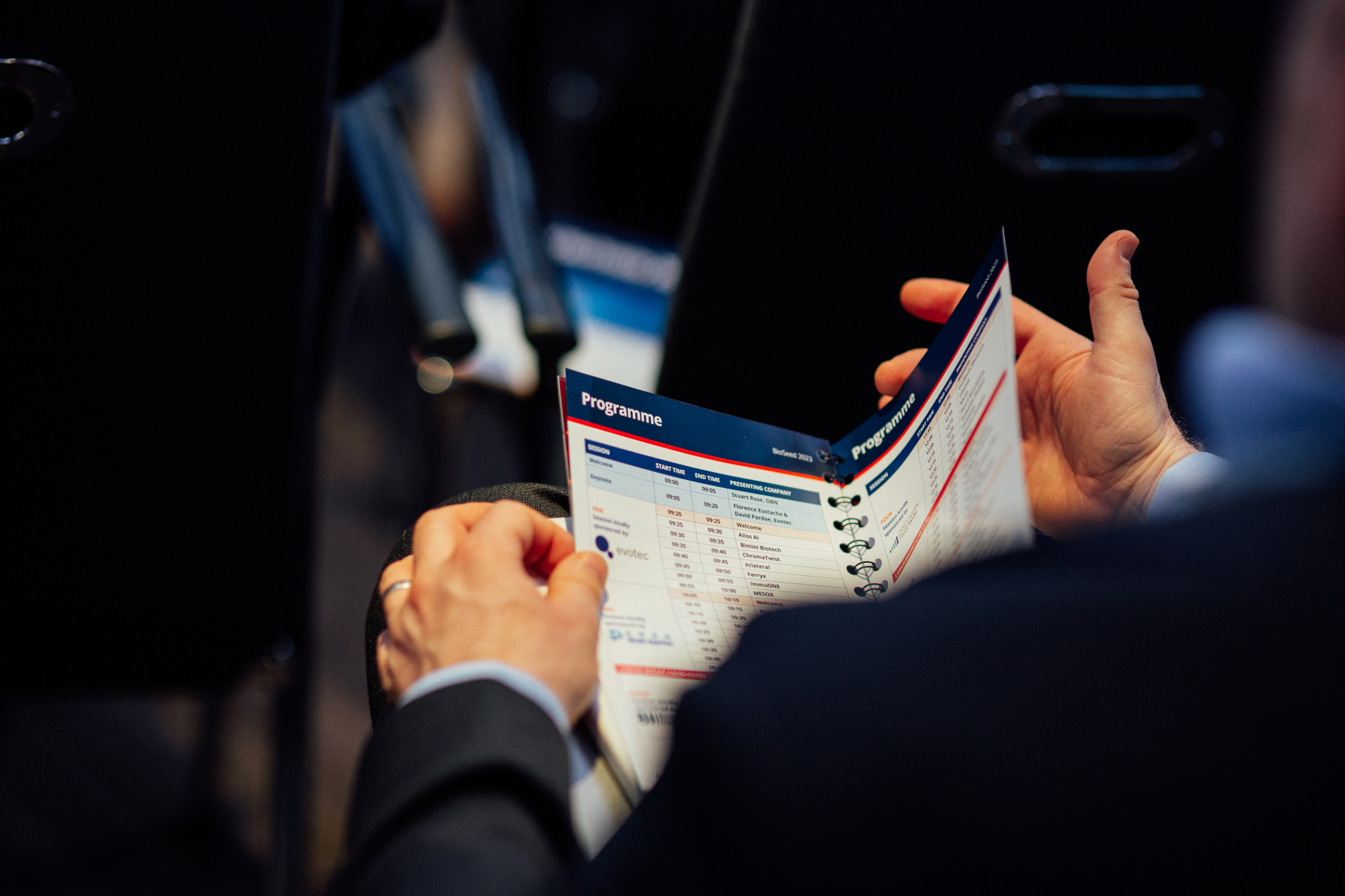 Photograph of a person holding the BioSeed handbook, viewing the "Programme" page.