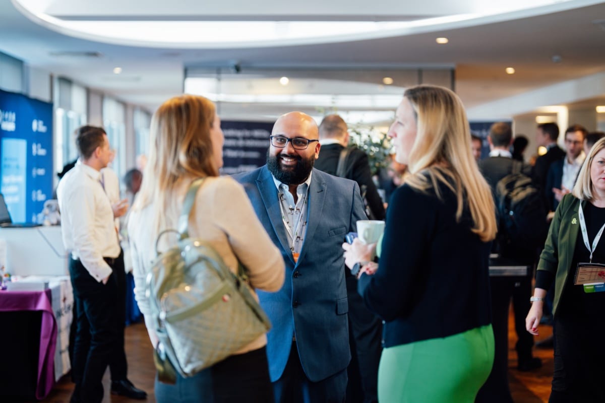 Photograph of a crowd of people networking at an event.