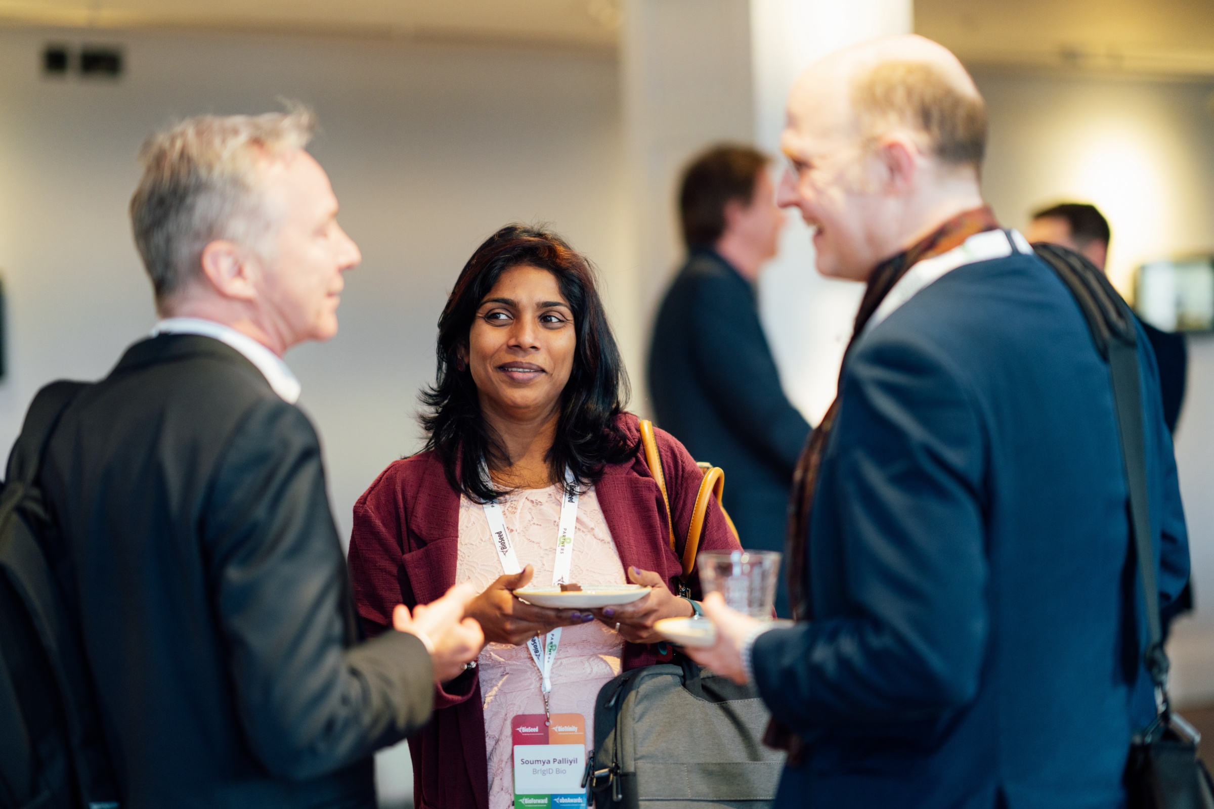 Photograph of three people having a discussion at an event.