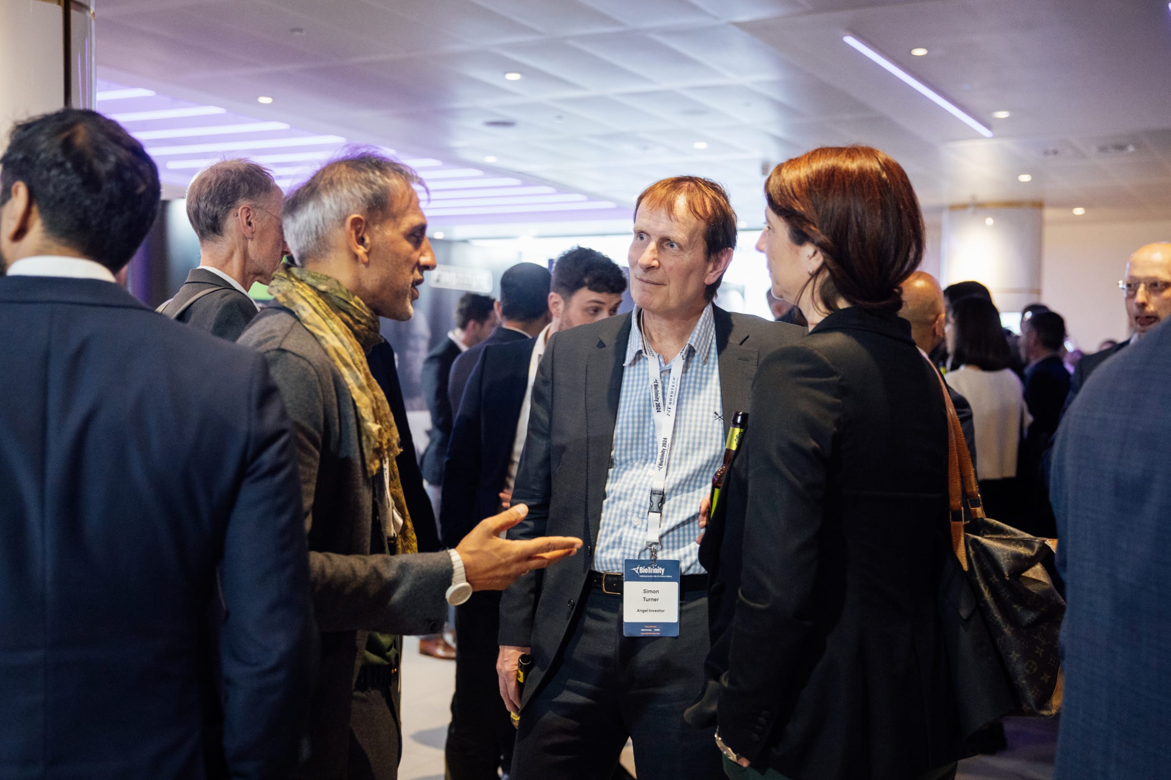 Photograph of a group of people networking at an event.