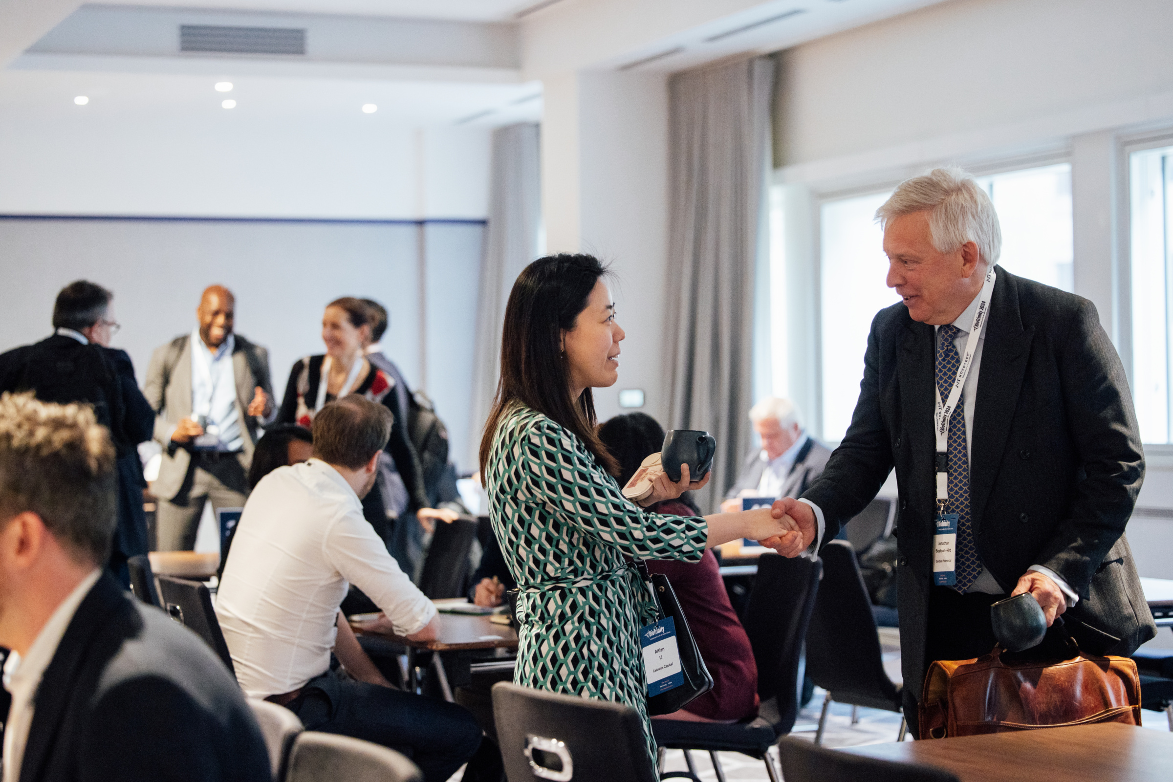 Photograph of two people shaking hands at a conference.