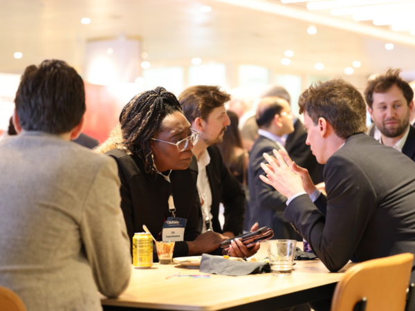 A group of people having a discussion at a table at BioTrinity 2024.