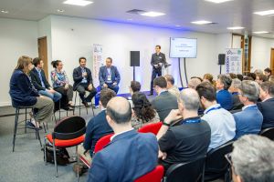 A panel of speakers watched by a seated audience