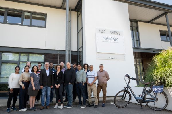 Photograph of a group of people standing outside their new office building. 