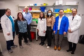 Photograph of a group of seven people in a laboratory setting. 